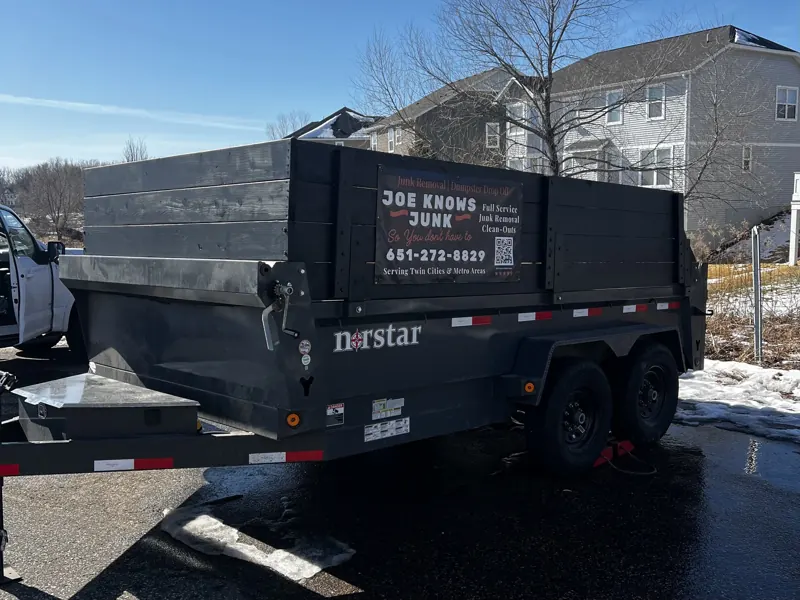 The Joe Knows Junk dump trailer parked in a driveway