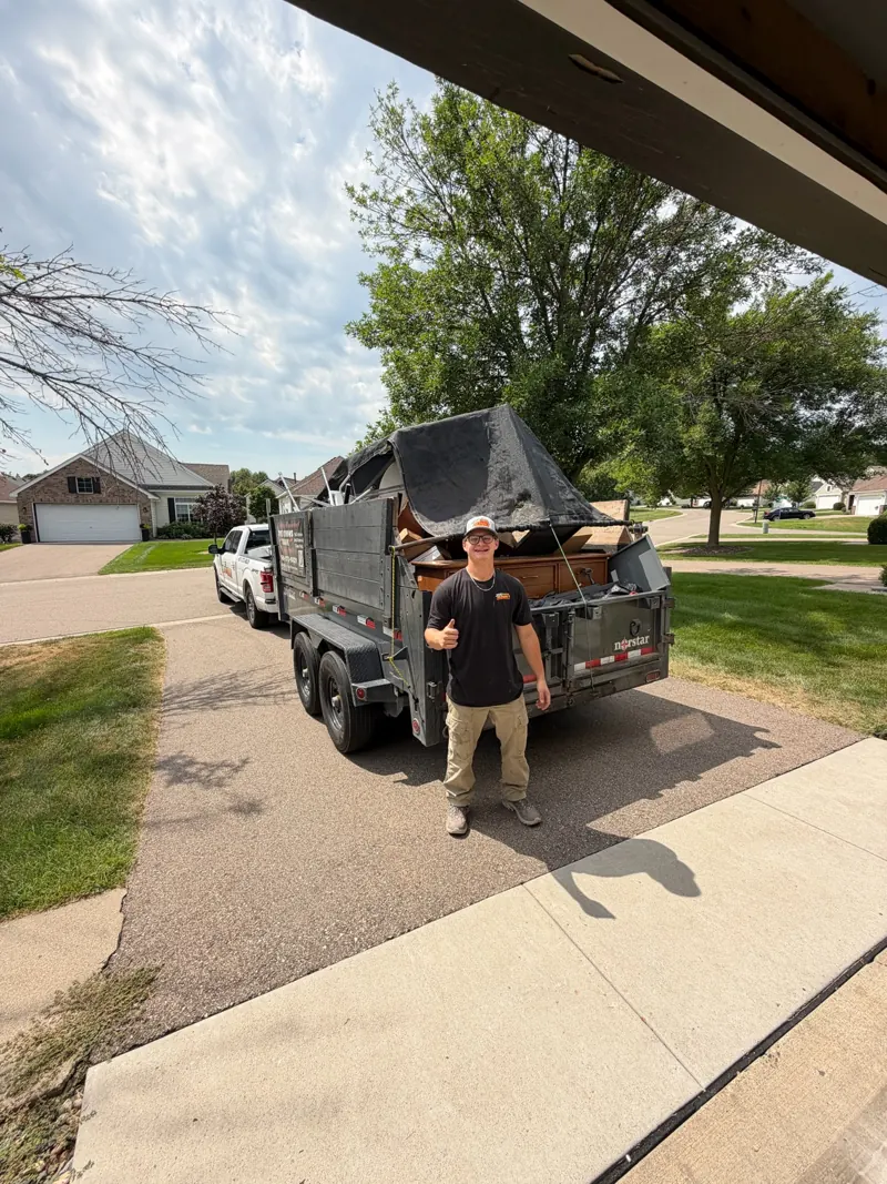 Joe next to a loaded trailer on a Twin Cities driveway
